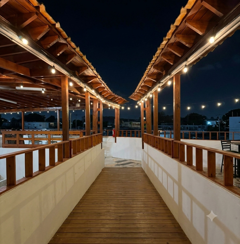 Don Guillermo second-floor terrace walkway at night with string lights